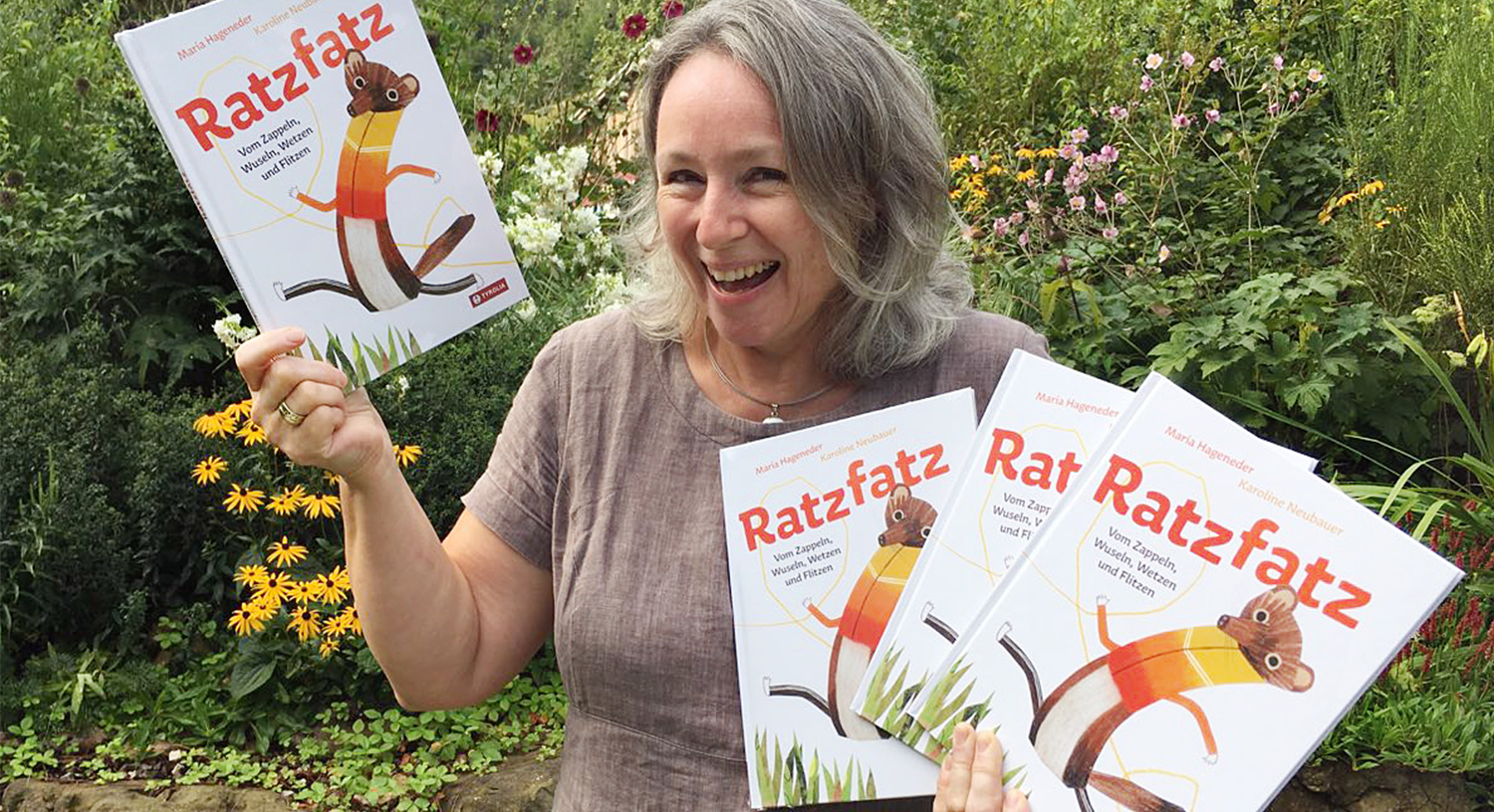 Die glückliche Autorin mit den frisch gedruckten Büchern in ihrem Garten